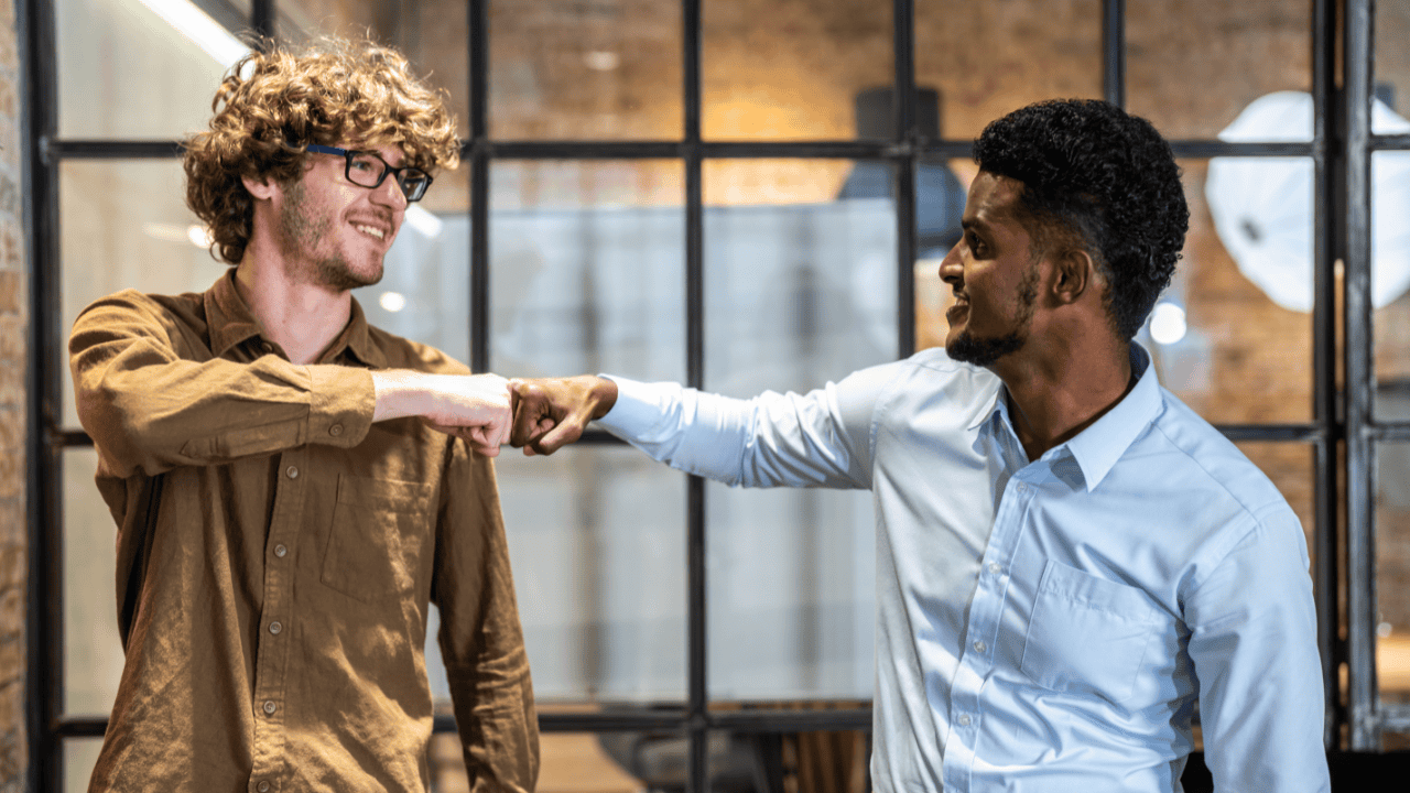 Two workers fist bumping.